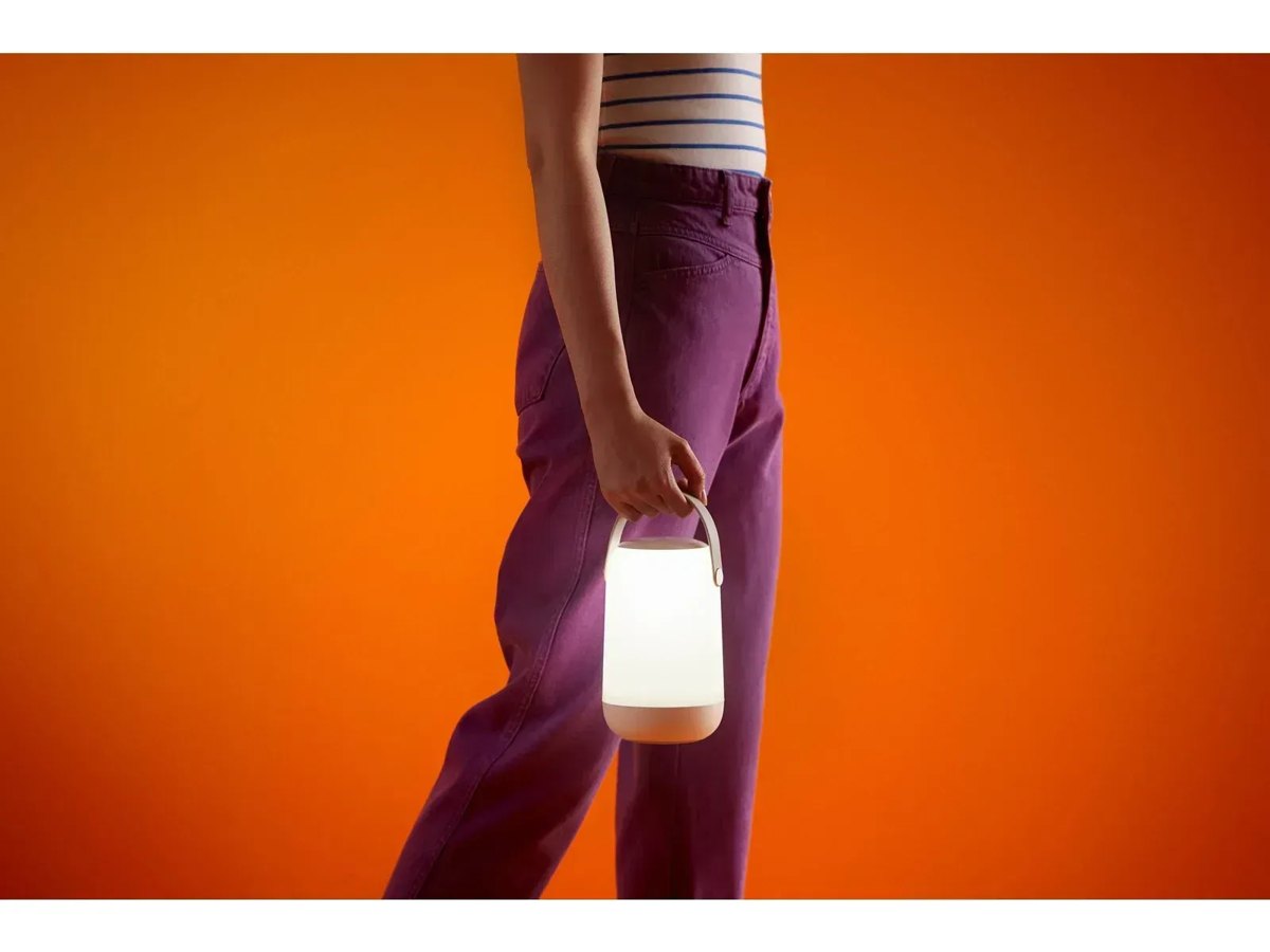 Людина несе увімкнену портативну лампу WiZ Mobile за ручку